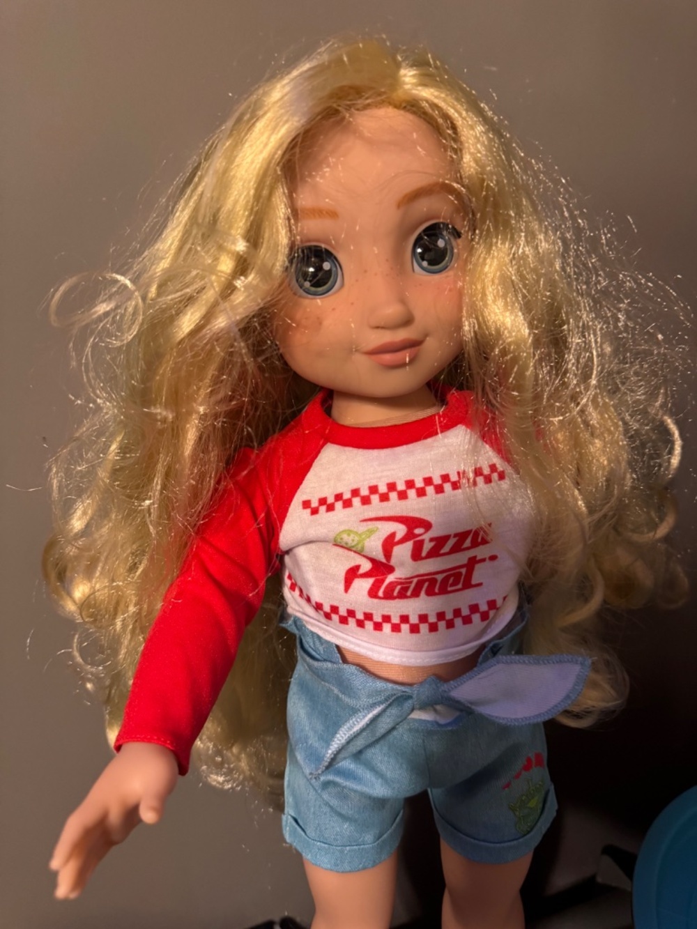 Disney ILY 4EVER 18-inch doll wears a Pizza Planet-inspired outfit featuring a r